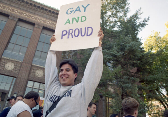 University of Michigan law student Wayne McCabe joins in the celebratory mood Wednesday of a National Coming Out Day rally f…