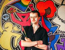 Samuel Turner in front of the mural he painted at Uplift in Ann Arbor. Photo: Andrew Potter