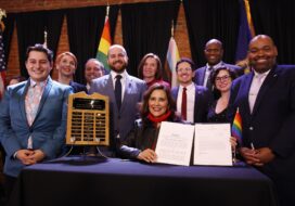 Gov. Whitmer, surrounded by Democratic legislators, after she signed the amendment to the Elliott-Larsen Civil Rights Act to protect LGBTQ+ Michiganders. Photo: State of Michigan