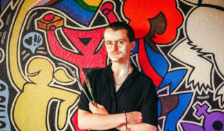 Samuel Turner in front of the mural he painted at Uplift in Ann Arbor. Photo: Andrew Potter