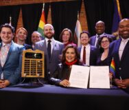 Gov. Whitmer, surrounded by Democratic legislators, after she signed the amendment to the Elliott-Larsen Civil Rights Act to protect LGBTQ+ Michiganders. Photo: State of Michigan