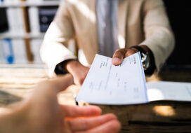 African Giving Cheque. Hand Holding Insurance Check