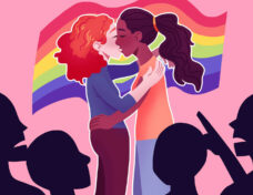 Two girls kissing with rainbow pride flag in the background, bei
