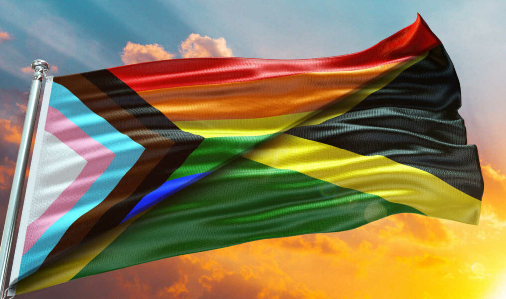 Jamaica Flag and New LGBT Rainbow Flag waving with texture Blue sky could and sunset Double flag