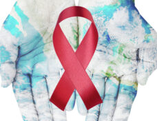 World map on hands with red ribbon on white background , world aids day concept