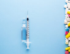 Vaccine With Syringe And Pills.vaccine With Syringe On A Blue Ba