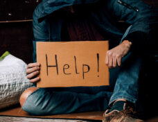 A Homeless Person Holds A Sign , Asks For Work, And Seeks Help.