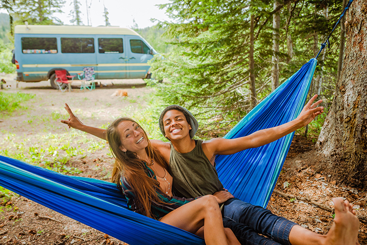 Lesbian couple in hammock out camping