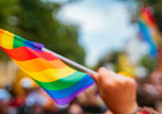 Hand hold a gay lgbt flag at LGBT gay pride parade festival-070712300
