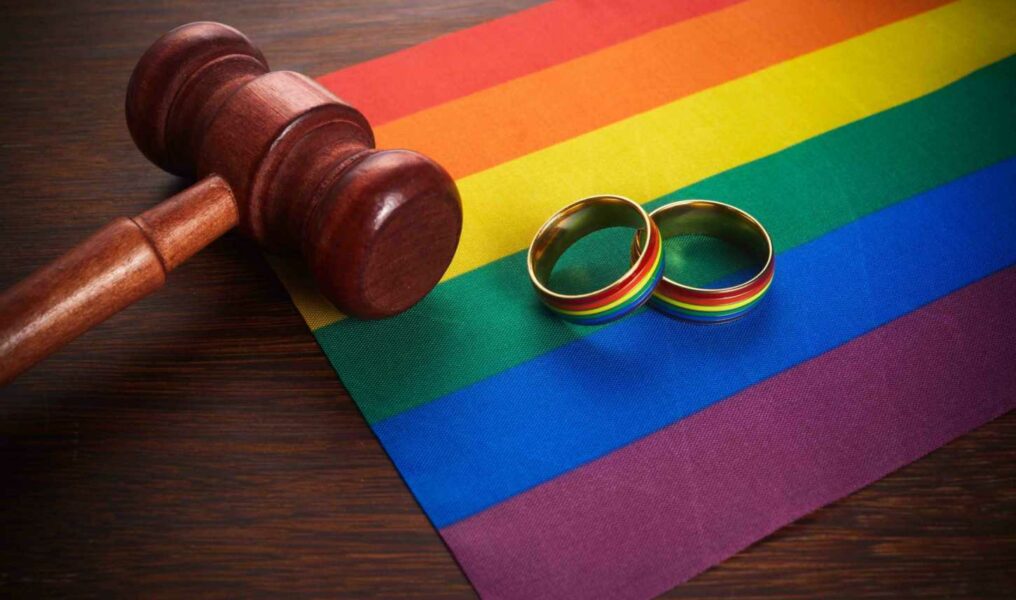 Two Gold Wedding Rings With Lgbt Rainbow Colours. Homosexual Marriage. Lgbt Rights And Law.