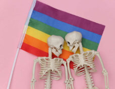 LGBT rainbow flag and two skeletons on pink background. Same sex relationships