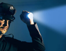 a police officer cop shines a flashlight during an investigation