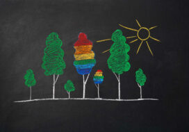 trees, sun and lgbt flag drawn by kid in chalk on school blackboard