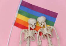 LGBT rainbow flag and two skeletons on pink background. Same sex relationships