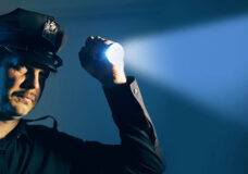 a police officer cop shines a flashlight during an investigation