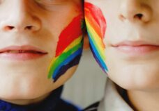 Two Kid Boys With Painted Rainbow With Colorful Colors On Face During Pandemic Coronavirus Quarantin