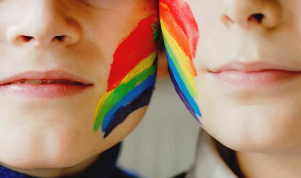 Two Kid Boys With Painted Rainbow With Colorful Colors On Face During Pandemic Coronavirus Quarantin