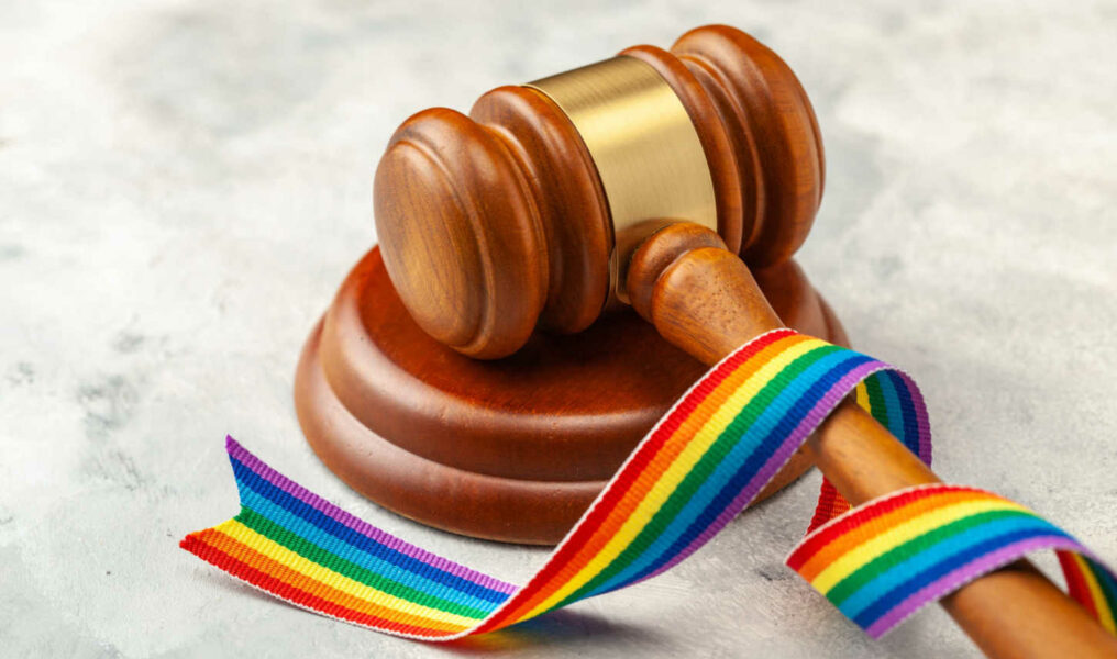 Judge gavel and rainbow ribbon of LGBT pride on gray background-070712441