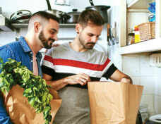 Gay men checking groceries in paper bag
