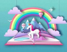 Open fairy tale book with unicorn, rainbow and mountain landscape. Cut out paper art style design