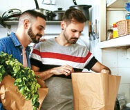 Gay men checking groceries in paper bag