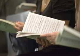 Choir singers holding musical score