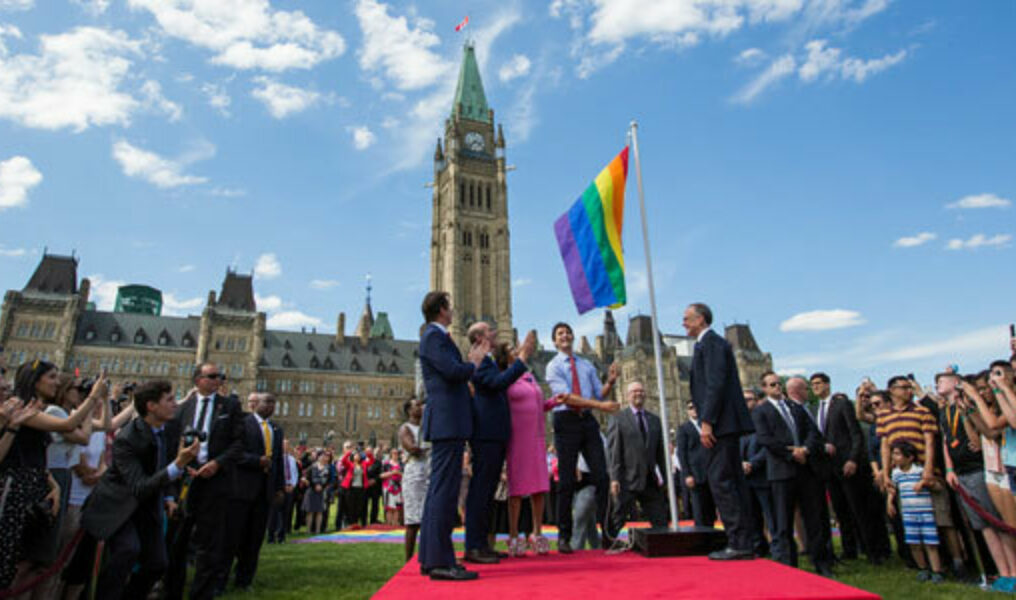 Justin_Trudeau_raising_rainbow_flag_460x470_courtesy_Pam_Lambo_of_the_Canadian_Embassy_in_the_US