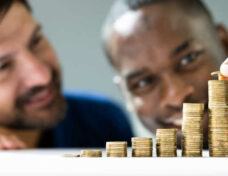 bigstock-Gay-Couple-Money-Save-And-Inve-430379221-scaled