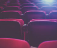 Rows of red seats in a cinema theater.