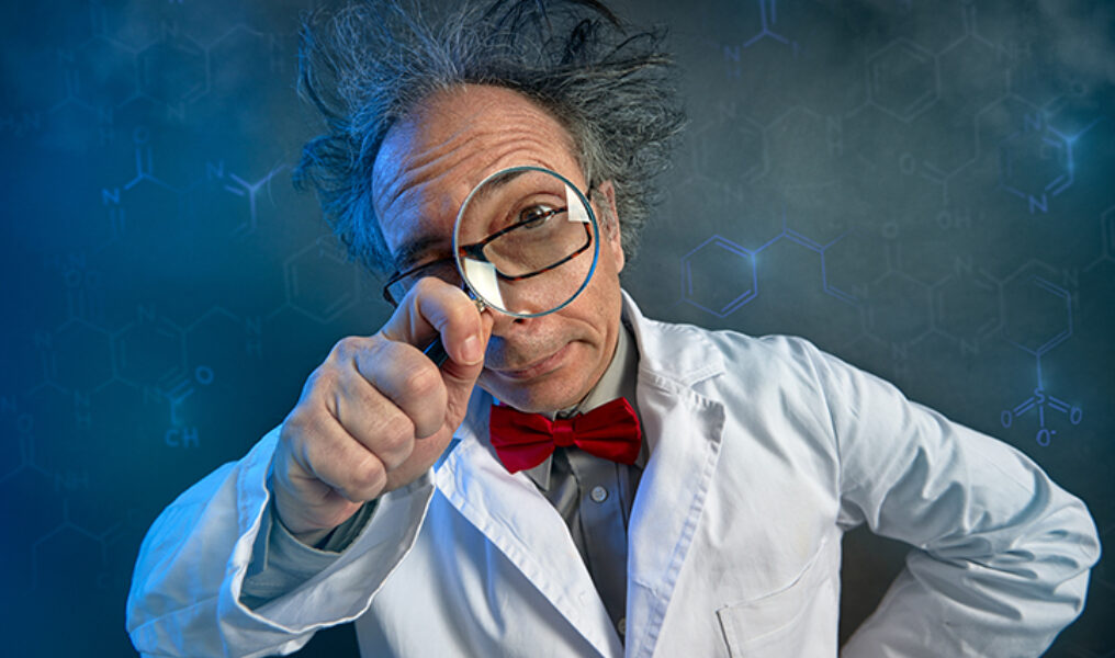 Funny scientist looking through a magnifying glass
