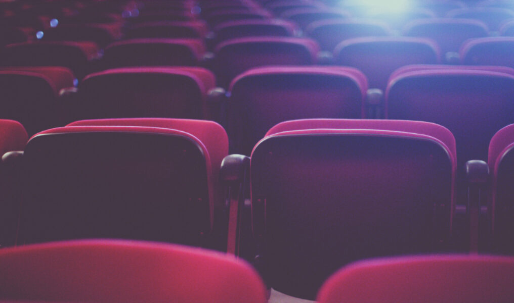 Rows of red seats in a cinema theater.